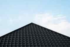 黑色的金属瓷砖屋顶屋顶金属表现代类型屋面材料屋顶房子金属屋顶瓷砖蓝色的天空建筑