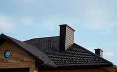 棕色（的）金属瓷砖屋顶屋顶金属表现代类型屋面材料屋顶房子金属屋顶瓷砖蓝色的天空建筑