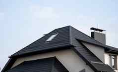 黑色的金属瓷砖屋顶屋顶金属表现代类型屋面材料屋顶房子金属屋顶瓷砖蓝色的天空建筑