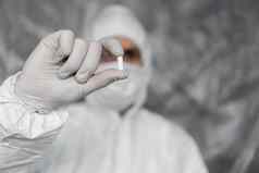 医生白色保护西装医疗面具橡胶手套持有白色药丸药物冠状病毒流感大流行威胁疫情流感大流行冠状病毒科维德