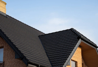 棕色（的）金属瓷砖屋顶屋顶金属表现代类型屋面材料屋顶房子金属屋顶瓷砖蓝色的天空建筑