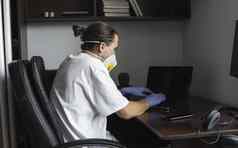 男人。医疗面具橡胶手套坐在首页表格作品移动PC检疫设计师艺术家架构师商人远程工作流感大流行科维德冠状病毒