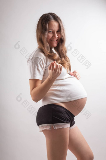 年轻的美丽的怀孕了女人经历强大的情绪白色背景