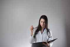 女医疗保健专业使请注意病人的负责孤立的灰色背景