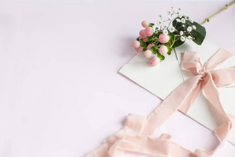 信封粉红色的背景桃子丝绸丝带粉红色的花婚礼邀请母亲的一天卡的地方文本复制空间