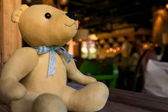 光棕色（的）可爱的熊坐着木表格