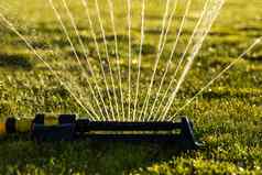 草坪上喷水灭火系统喷涂水绿色草现代设备灌溉花园草灌溉系统技术浇水花园浇水草坪上喷水灭火系统