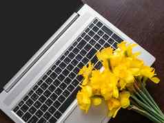 花束那喀索斯水仙花说谎银金属移动PC明亮的黄色的花可移植的设备木背景