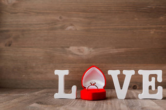 词爱钻石订婚环红色的礼物盒子木背景象征爱婚姻好<strong>情人节</strong>一天卡的地方文本