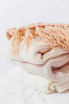 桩米色羊毛衣服白色背景温暖的针织毛衣围巾折叠堆
