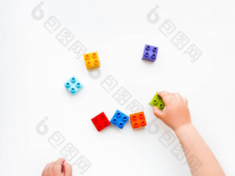 孩子玩色彩斑斓的构造函数块儿童手砖玩具白色背景教育玩具平躺前视图