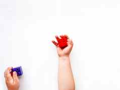 孩子霍利登紫罗兰色的红色的构造函数块的拳头儿童手玩具白色背景平躺前视图