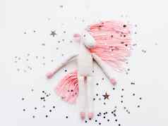 可爱的仙女独角兽粉红色的鬃毛尾巴使线程钩针编织的手使玩具白色背景银星星五彩纸屑时尚的生物象征魔法奇迹