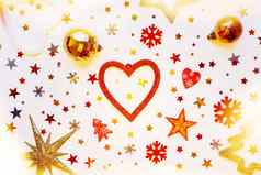 圣诞节一年假期背景装饰光灯泡红色的金心闪亮的球感觉雪花明星五彩纸屑平躺前视图