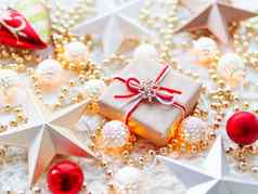 圣诞节一年明星装饰白色针织背景现在盒子包装工艺纸雪花象征金属光灯泡精致的模式金珠子红色的球
