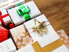圣诞节礼物破旧的木背景礼物白色金纸明亮的金riboons闪闪发光的明星五彩纸屑