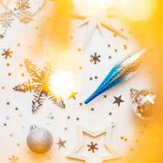 圣诞节一年假期背景装饰光灯泡银蓝色的闪亮的球白色雪花明星五彩纸屑平躺前视图