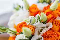 一对金婚礼环内部新娘花束象征爱婚姻橙色玫瑰eustoma桔梗传统的新娘的附件