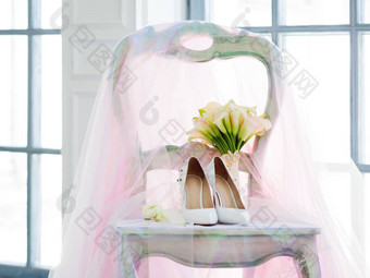 白色鞋子闪闪发光的粉红色的面纱新娘花束马蹄莲百合细节婚礼仪式
