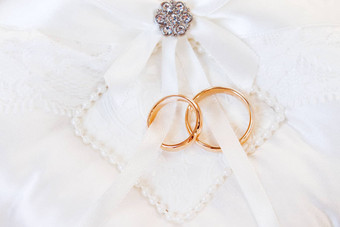 金婚礼环<strong>白色丝绸背景</strong>婚礼细节象征爱婚姻