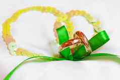 金婚礼环点缀丝绸背景绿色丝带象征爱婚姻
