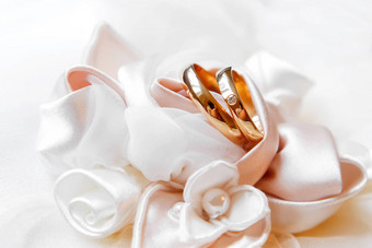金婚礼环钻石丝绸玫瑰婚礼珠宝细节柔和的白色织物