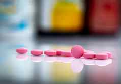 粉红色的平板电脑药片模糊背景药物瓶药物