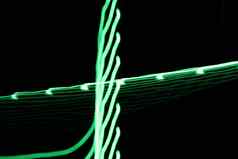 绿色霓虹灯光行曲线摘要图像黑色的背景由于相机摇长曝光时间