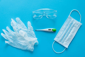 医疗保护面具橡胶手套温度计保护眼镜谎言粉红色的背景反病毒保护工具包科维德冠状病毒流感大流行