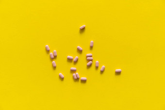 粉红色的药片黄色的背景医学药物治疗止痛药平板电脑医生药物抗生素维生素治疗药店主题前视图药片分散白色表面