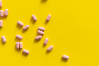 粉红色的药片黄色的背景医学药物治疗止痛药平板电脑医生药物抗生素维生素治疗药店主题前视图药片分散白色表面