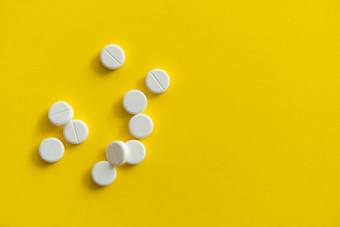 白色药片黄色的背景医学药物治疗止痛药平板电脑医生药物抗生素维生素治疗药店主题前视图药片分散白色表面