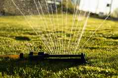 草坪上喷水灭火系统喷涂水绿色草现代设备灌溉花园草灌溉系统技术浇水花园浇水草坪上喷水灭火系统