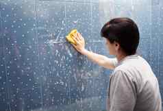 女人洗瓷砖墙布泡沫