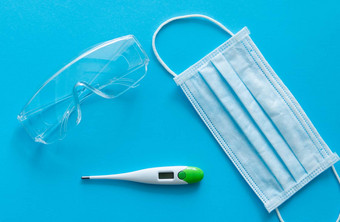 医疗保护面具温度计保护眼镜谎言蓝色的背景反病毒保护工具包科维德冠状病毒流感大流行