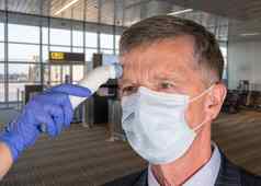 高级男人。穿脸面具温度检查病毒机场
