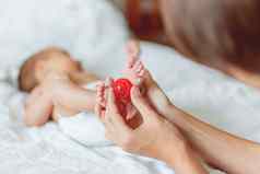 妈妈。持有新生儿婴儿的脚小手指红色的按摩球女人的手舒适的早....首页