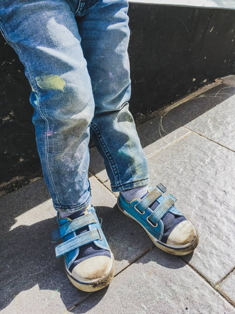 蹒跚学步的牛仔裤吸引了蜡笔沥青阳光明媚的一天儿童牛仔裤运动鞋覆盖色彩斑斓的污渍户外休闲活动