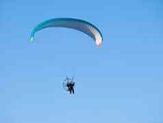 男人。飞行滑翔伞滑翔机电动机车辆清晰的蓝色的天空