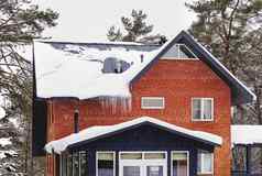 红色的砖国家房子冬天松树森林屋顶冰柱雪