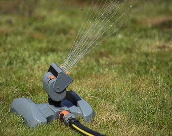振荡灌溉喷水灭火系统草坪上中午特写镜头