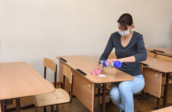 女孩倒清洁消毒液桌子上学校检疫期