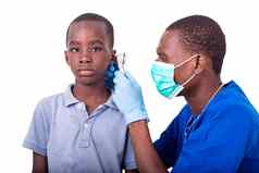 年轻的儿科医生医生检查耳朵男孩