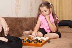 女孩玩国际跳棋妈妈。