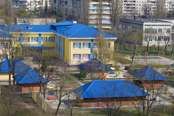 明亮的蓝色的屋顶幼儿园背景灰色的城市高层建筑