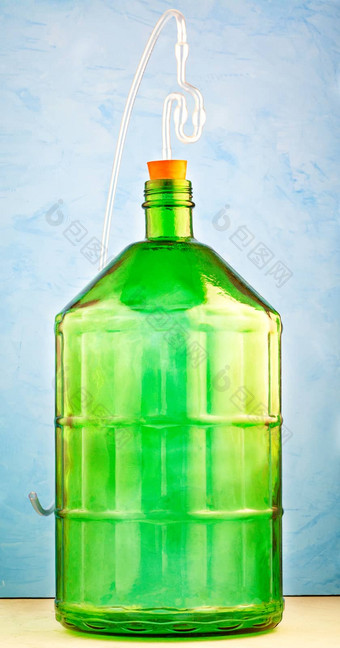 升玻璃Jar使厚绿色玻璃水锁定图像蓝色的背景