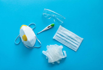 医疗保护面具呼吸器断续器橡胶手套温度计保护眼镜谎言蓝色的背景反病毒保护工具包科维德冠状病毒流感大流行
