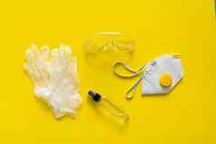 呼吸器断续器橡胶手套防腐剂保护眼镜谎言黄色的背景反病毒保护工具包科维德冠状病毒流感大流行