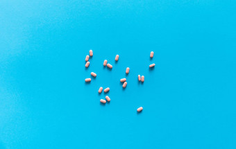 粉红色的药片蓝色的背景医学药物治疗止痛药平板电脑医生药物抗生素维生素治疗药店主题前视图药片分散蓝色的表面