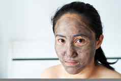 亚洲女人应用木炭面具只脸